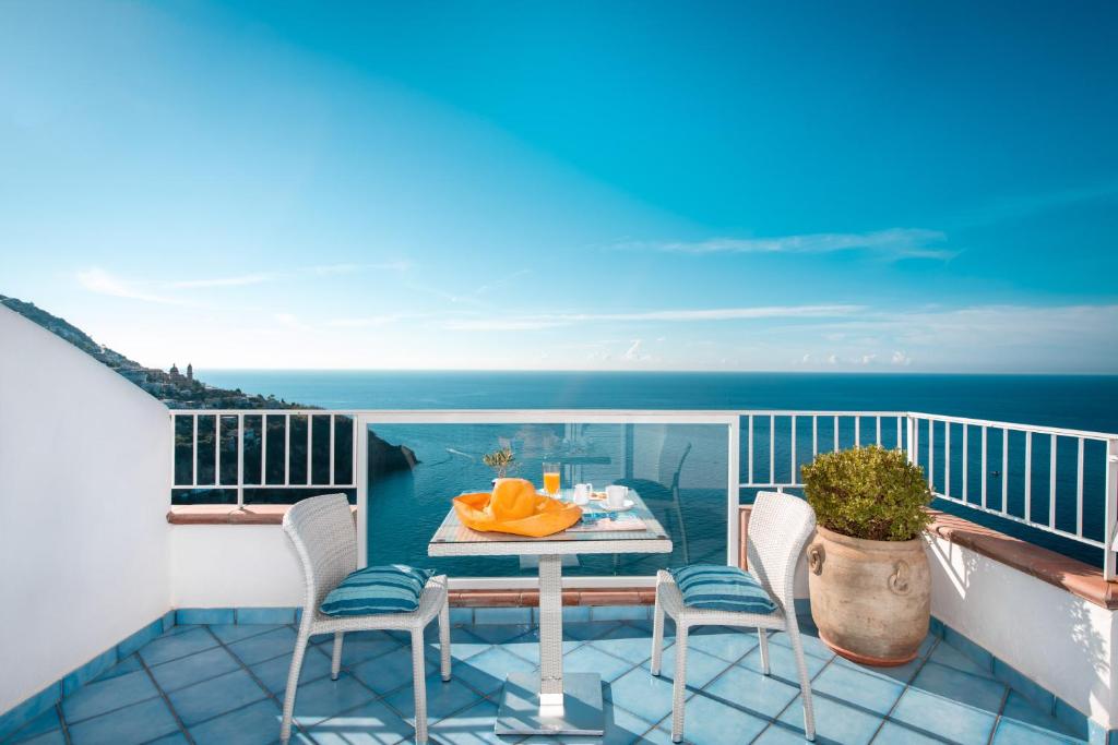 普莱伊亚诺特里托尼大酒店的一个带桌椅的海景阳台