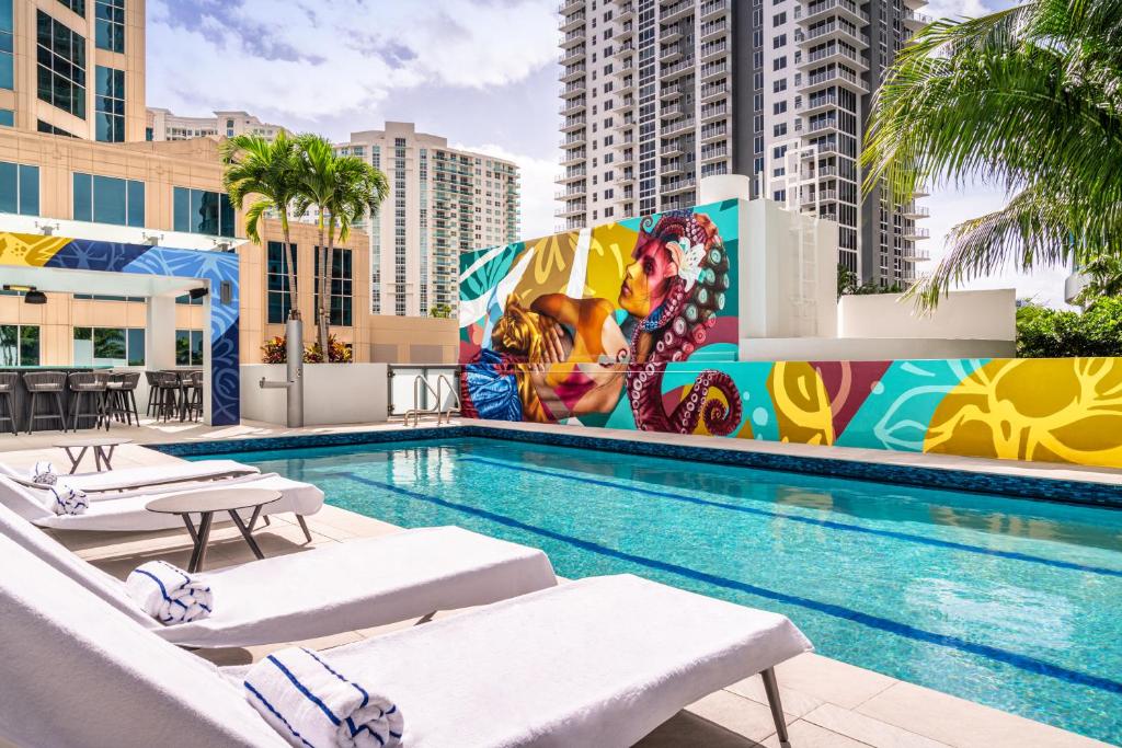 劳德代尔堡Hyatt Centric Las Olas Fort Lauderdale的一个带躺椅和壁画的游泳池