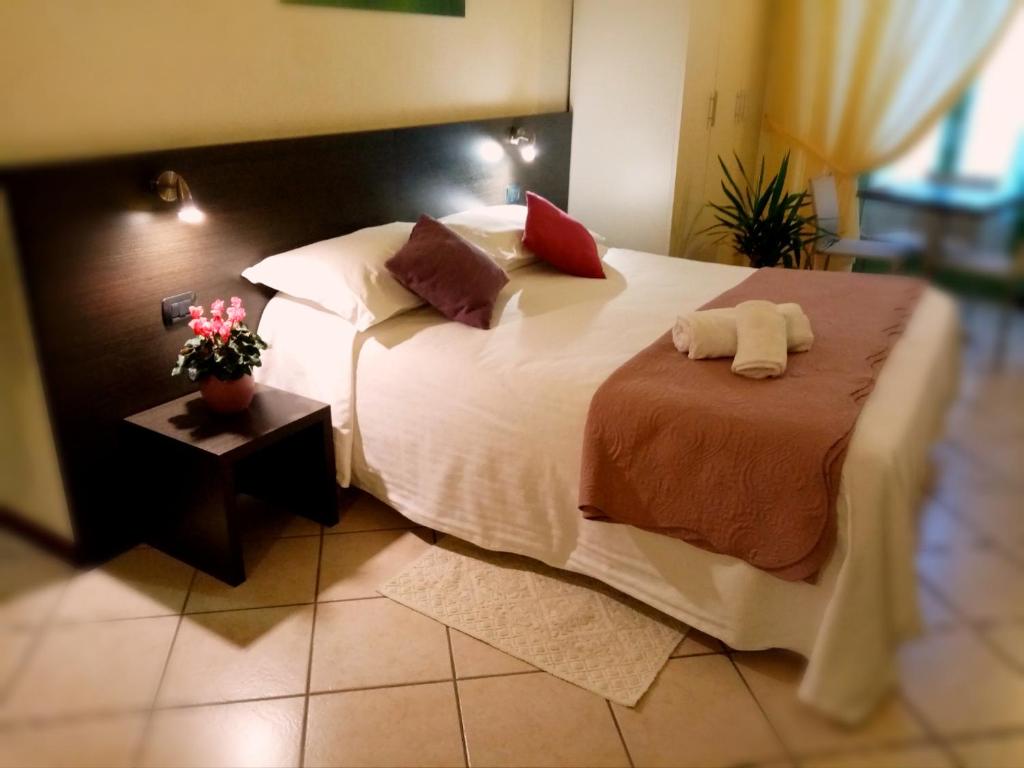 库尼奥利古雷酒店的一间卧室配有一张大床和两个枕头