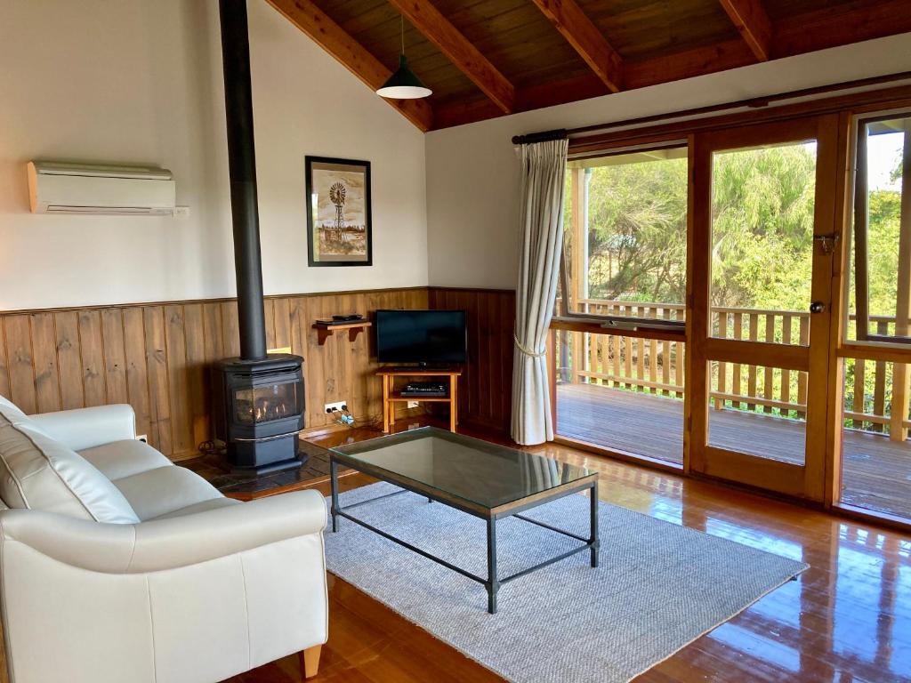 坎贝尔港戴茜山乡村山林小屋的带沙发、桌子和炉灶的客厅