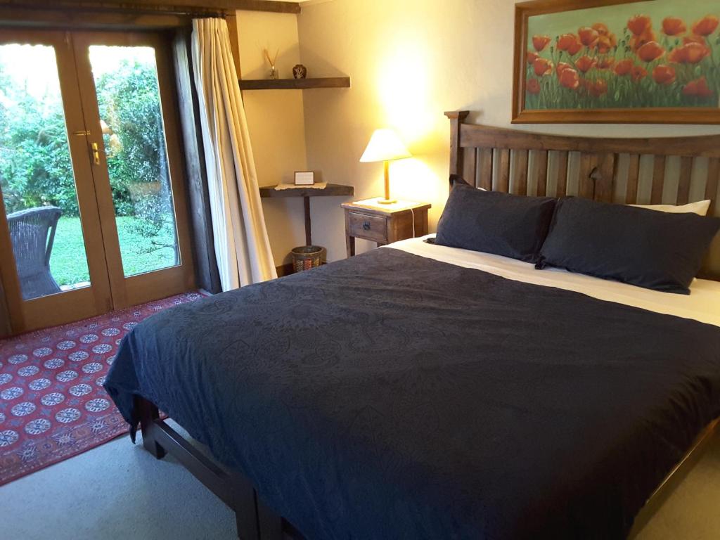 瓦纳卡Wanaka Stonehouse的一间卧室设有一张大床和一个窗户。