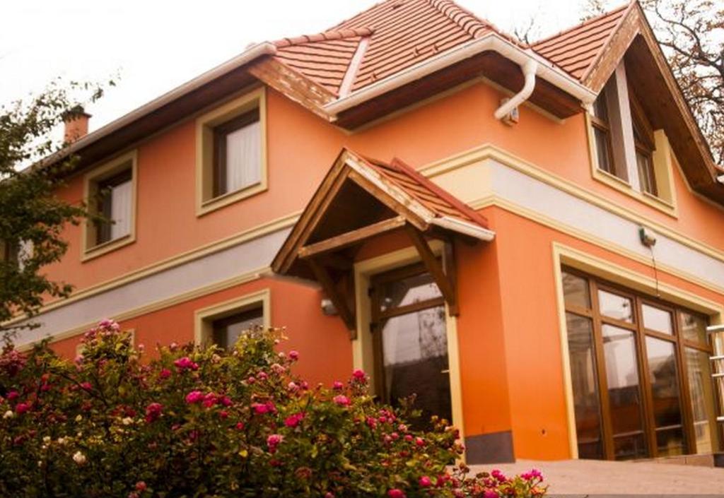 CsákvárPublo Étterem és Panzió的橙色房子,有棕色的屋顶