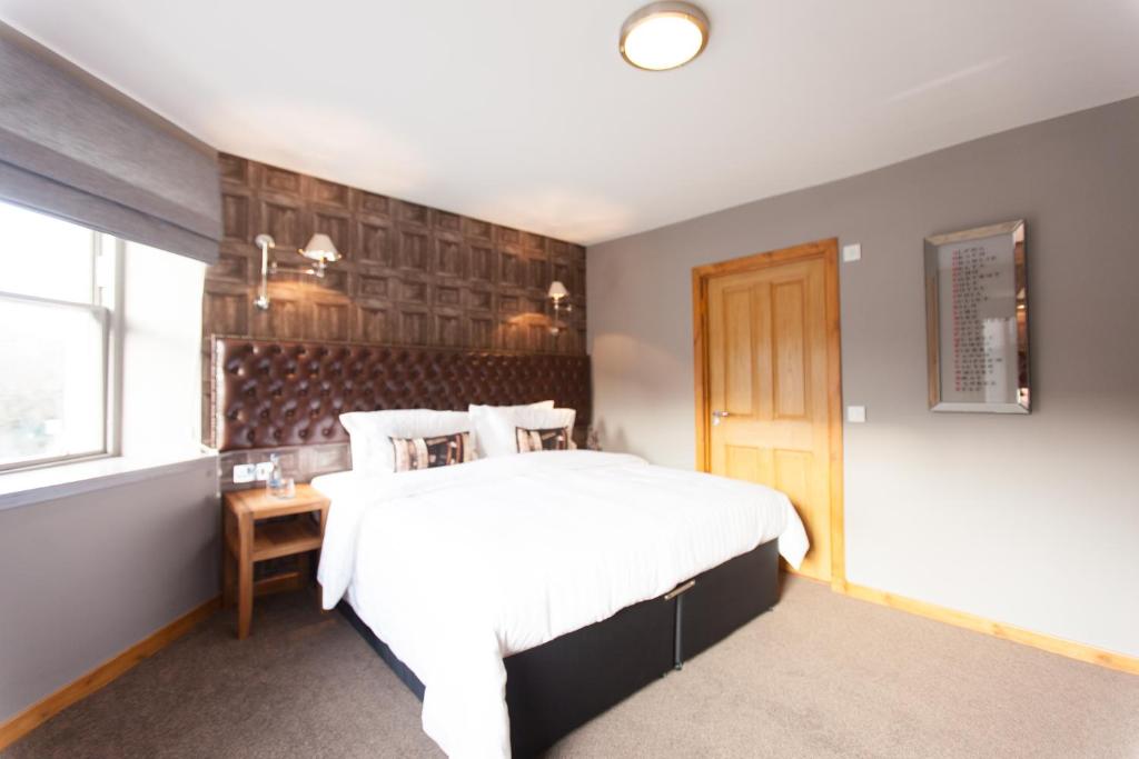 加拉希尔斯鲑鱼宾馆的卧室设有一张白色大床和一扇窗户。