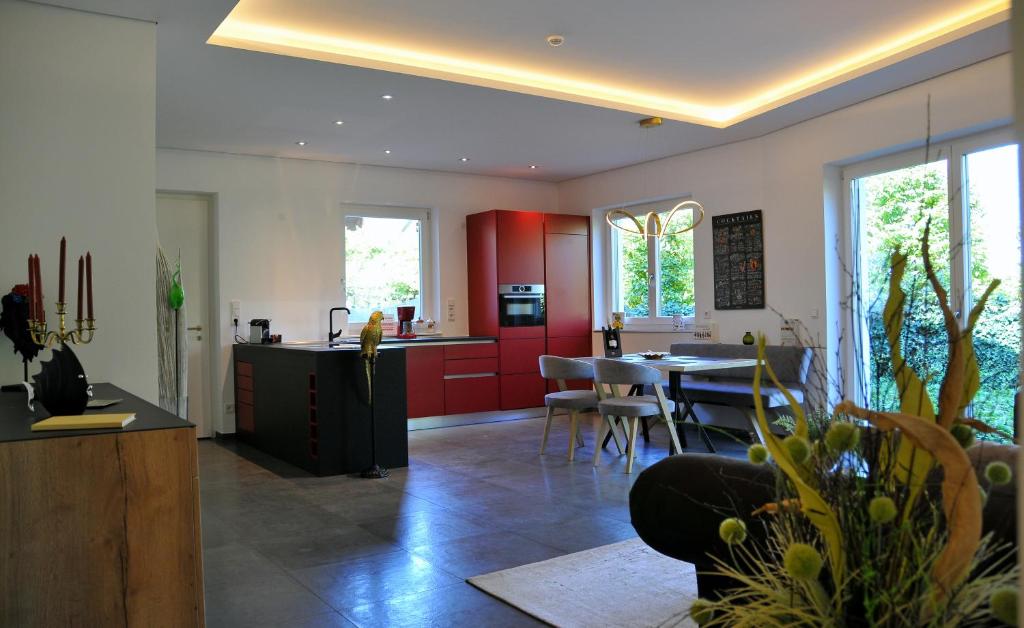马伦格Ruhige Ferienwohnung mit Garten und Garage in Privatvilla的一间厨房和带红色橱柜及桌子的用餐室
