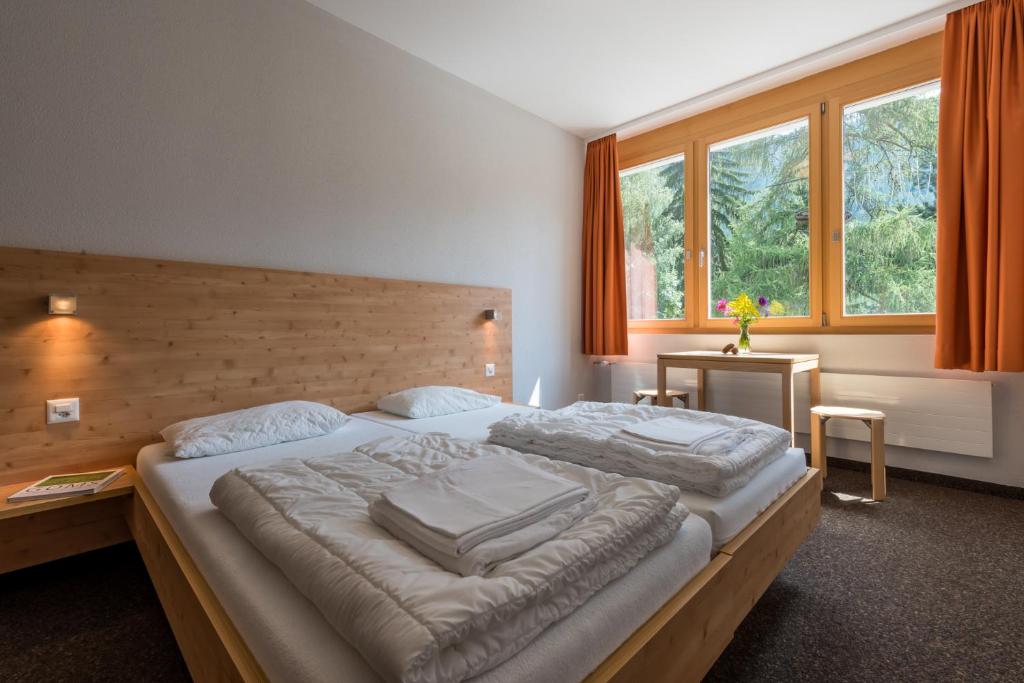 菲施Sport Resort Fiesch - Fiescher Hostel的一间卧室设有一张大床和一个窗户。