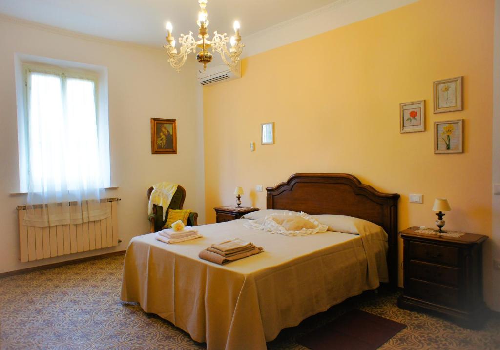圣米尼亚托Casa Fonte di Bacco的一间卧室配有一张床和一个吊灯