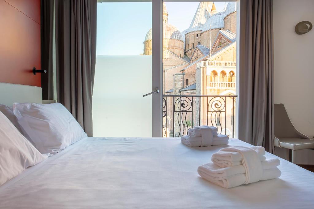 帕多瓦Padova Suites C20的酒店客房,配有带毛巾的床