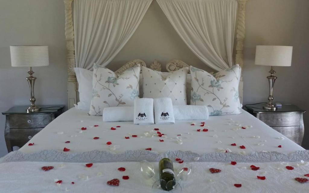 斯泰伦博斯Slaley Country House的一张白色的床,上面有红色的玫瑰花垫