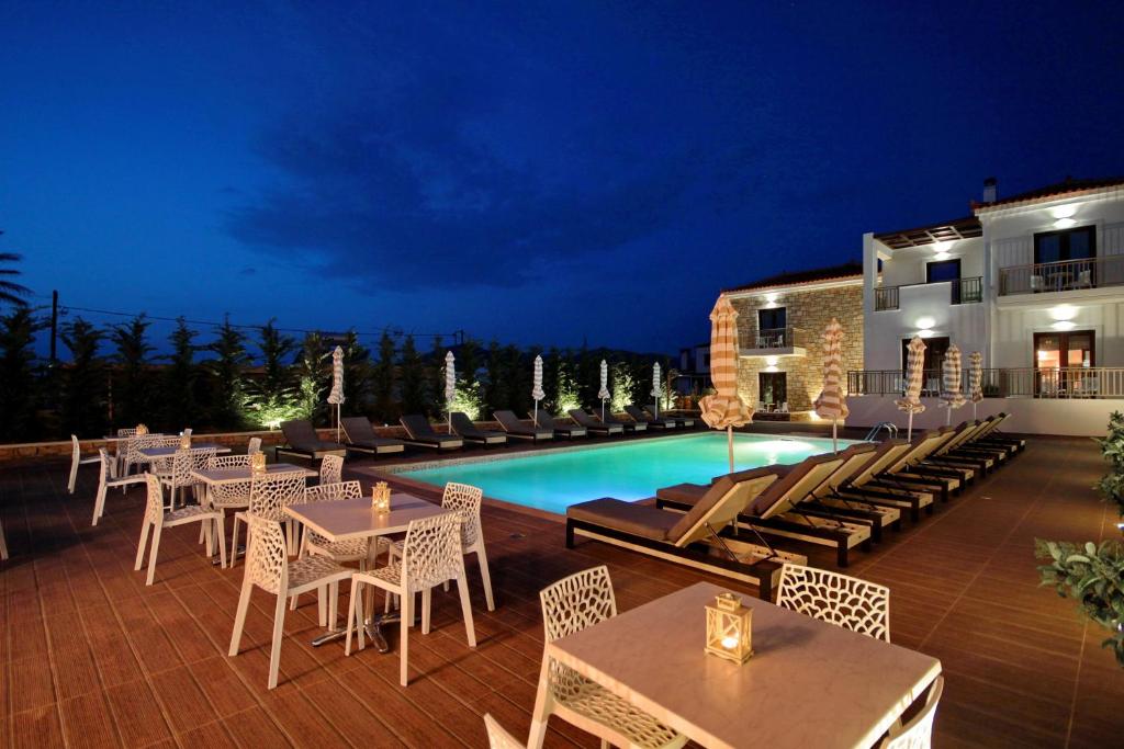 艾拉方索斯Elafonisos Resort的游泳池旁带桌椅的天井