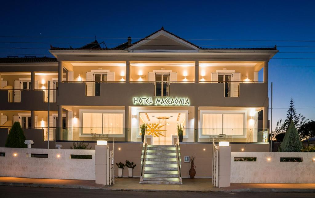 卡拉马孔马其顿酒店的一座白色的大建筑,灯火通明