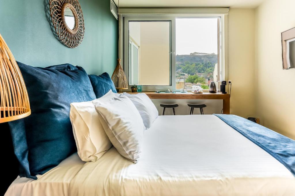 雅典Ciel Living Athens的一间卧室配有一张蓝色墙壁的床和一扇窗户