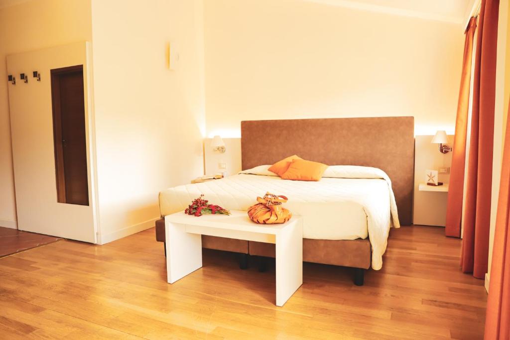 蓬特雷莫利卡德尔摩洛度假酒店的一间卧室配有一张床和一张带南瓜的桌子。