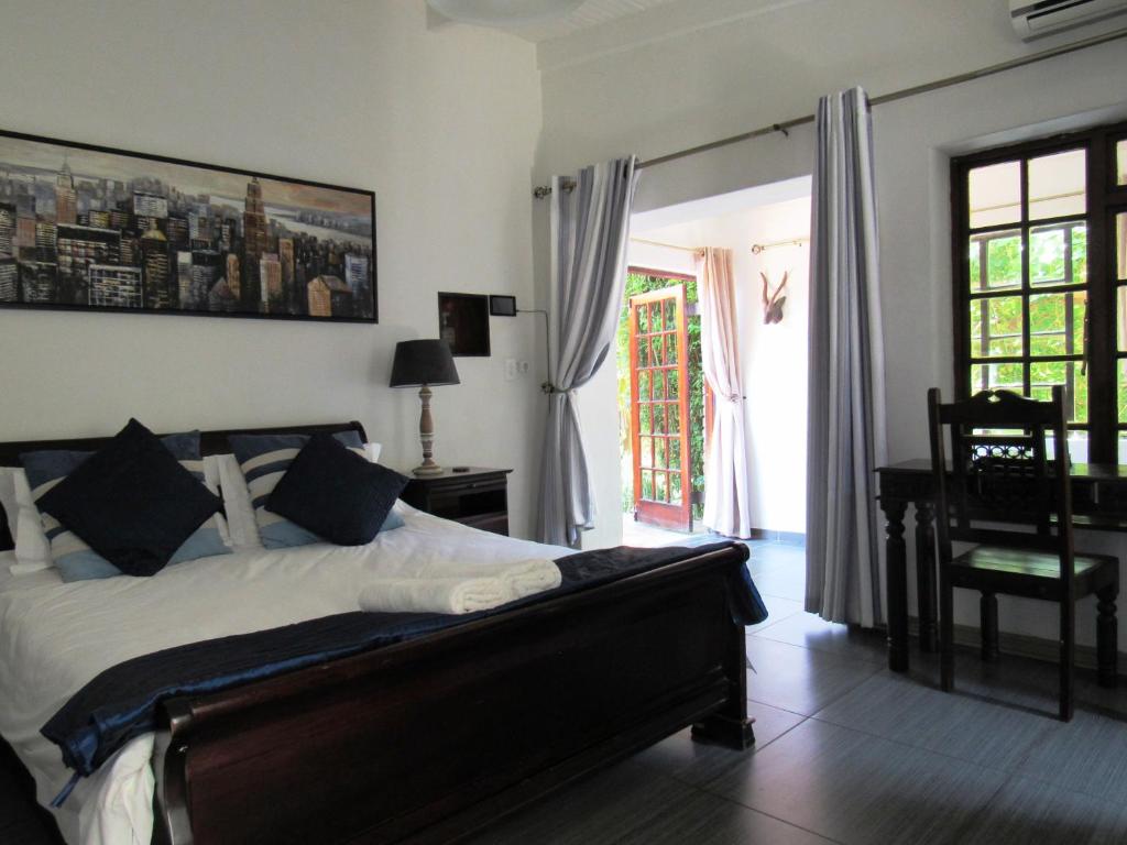 约翰内斯堡约克之家酒店的一间卧室配有一张床、一张书桌和一个窗户。