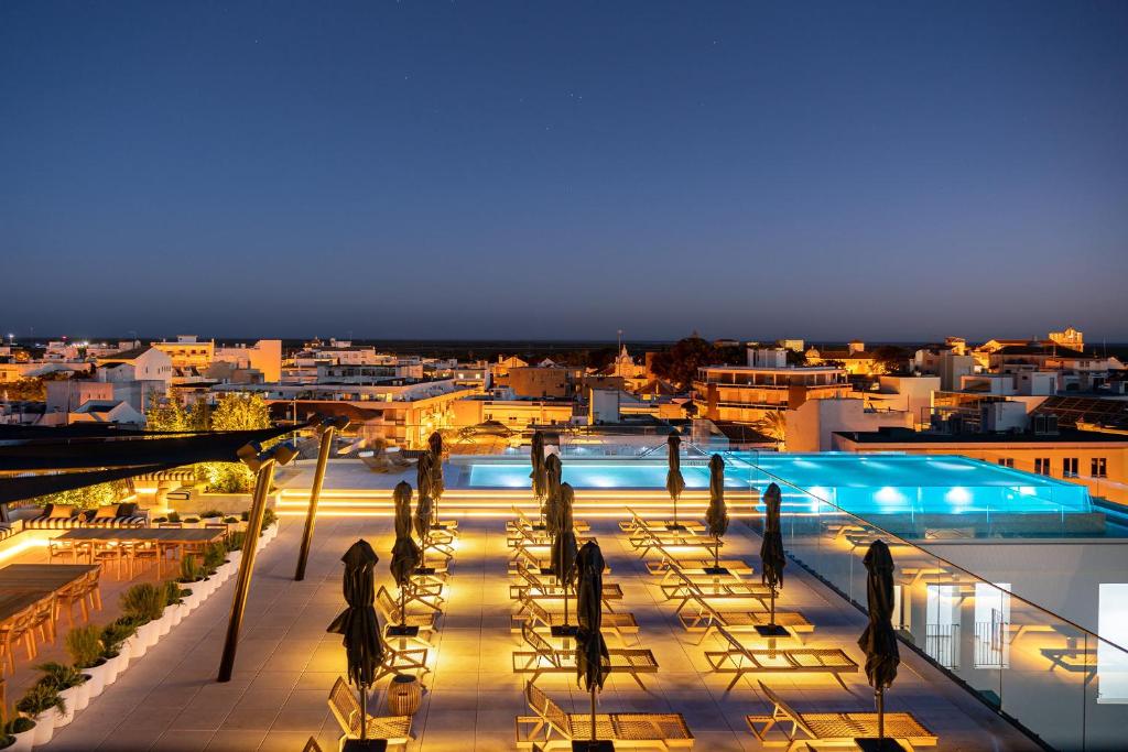 法鲁3HB Faro的享有带游泳池的大楼的夜间景致