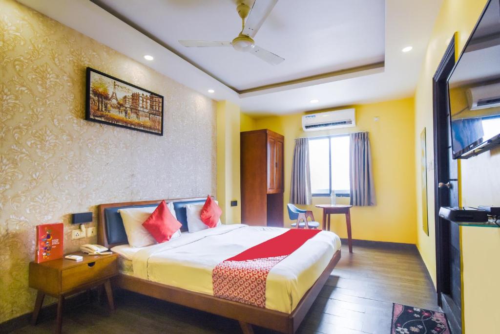加尔各答Kiaan Inn的酒店客房配有一张床铺和一张桌子。