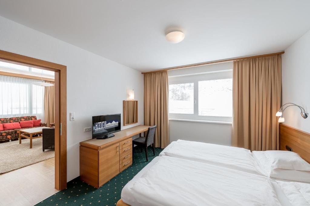 奥伯古格尔蒙大拿州木屋酒店的配有一张床和一张书桌的酒店客房