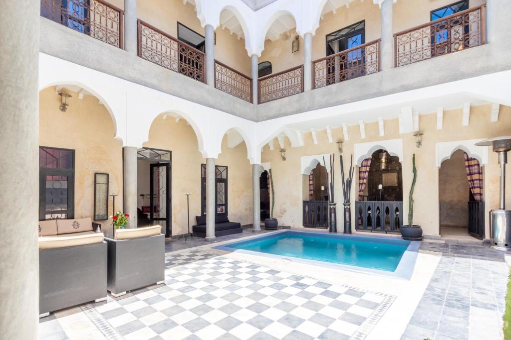 马拉喀什里亚德厄尔马萨旅馆的一个带游泳池和大楼的室内庭院