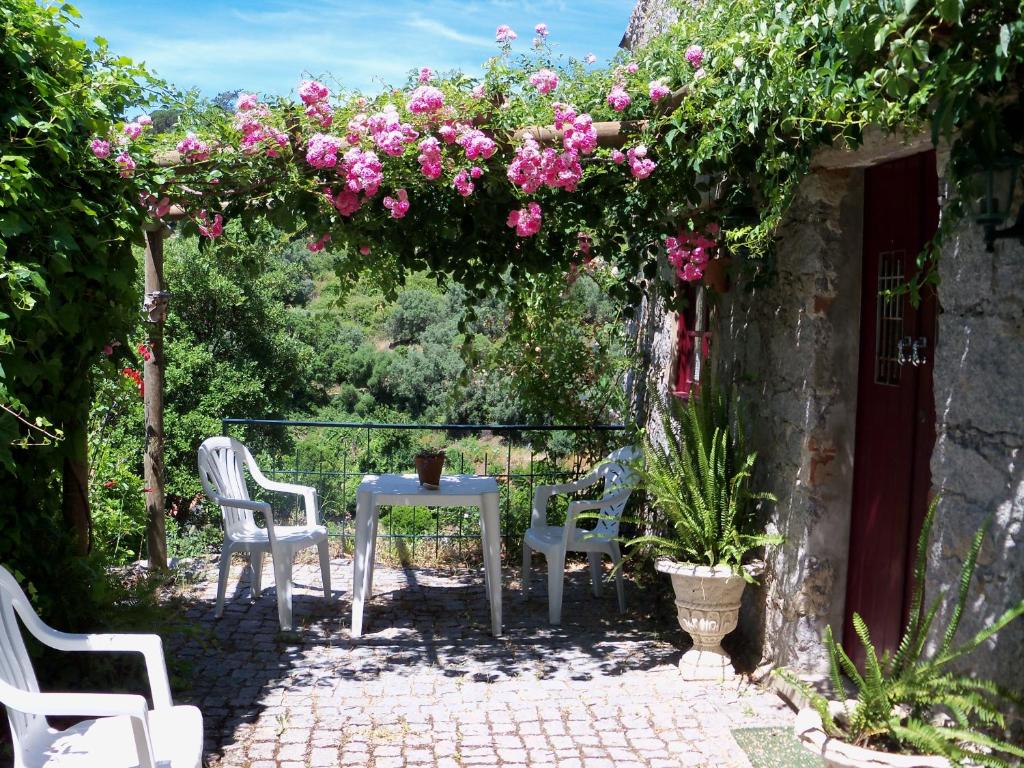 蒙希克我的房间-维娜别墅®- TER乡村民宿的庭院配有桌椅和粉红色的鲜花。