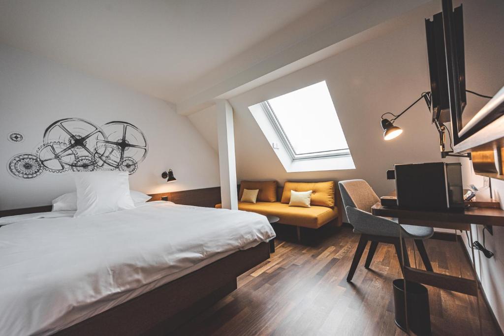 日内瓦日内瓦伯尔尼纳酒店的一间卧室配有一张床、一张书桌和一个窗户。