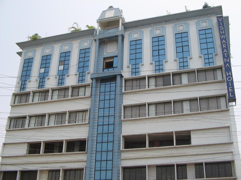 古瓦哈提维士瓦拉塔纳酒店的上面有蓝色标志的高大的白色建筑