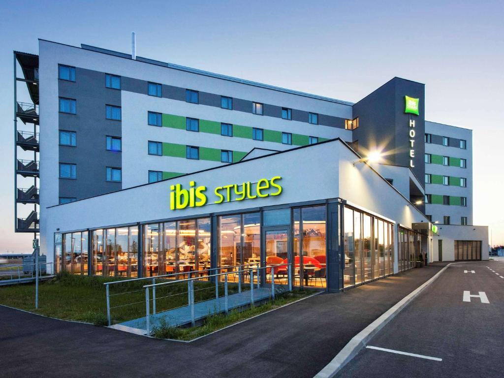 帕恩多夫ibis Styles Parndorf Neusiedler See的上面有一条公共汽车条纹的建筑