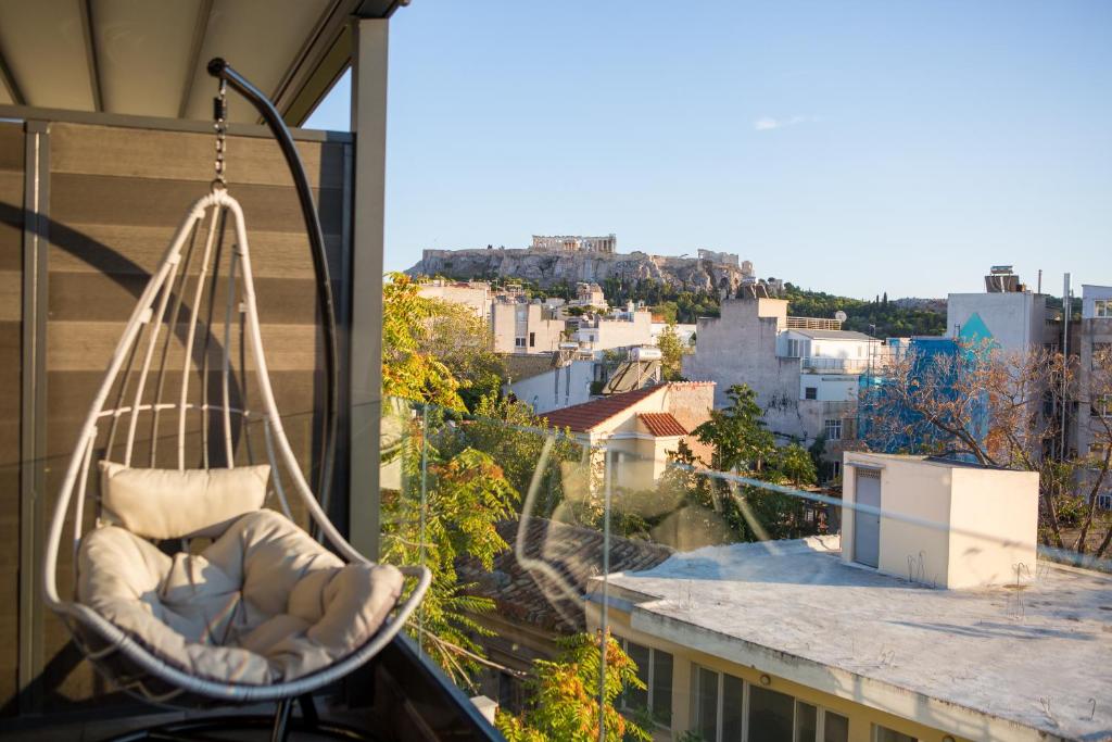 雅典Raise Acropolis View Suites的悬挂在城市阳台的秋千