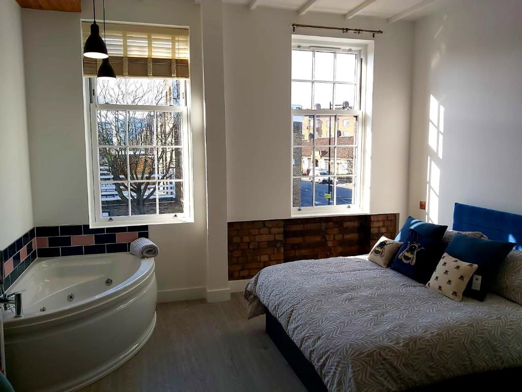 伦敦Angel Townhouse的一间带浴缸、床和窗户的卧室