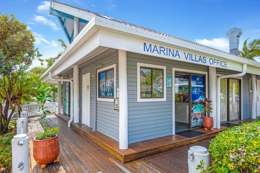 帝坎湾Tin Can Bay Marina Villas的木甲板上的码头别墅办公室
