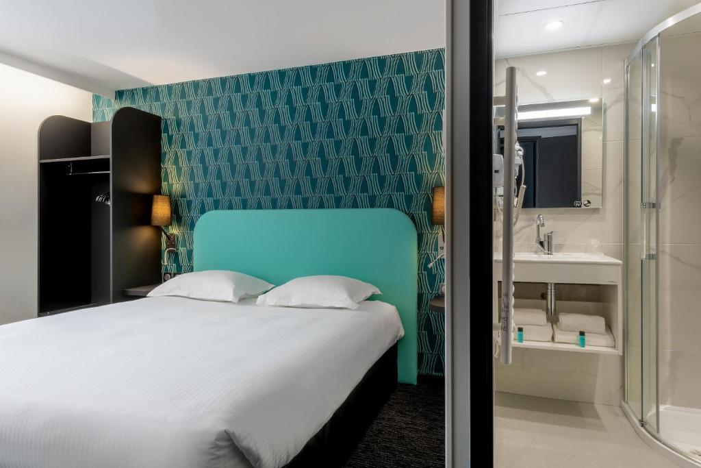 凯恩Zenith Hotel Caen的一间带大床的卧室和一间浴室
