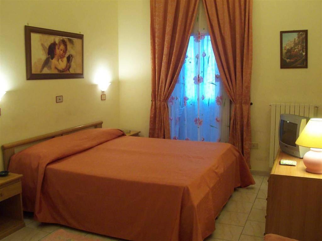 巴里盆西奥罗密欧酒店的一间卧室配有一张大床和电视