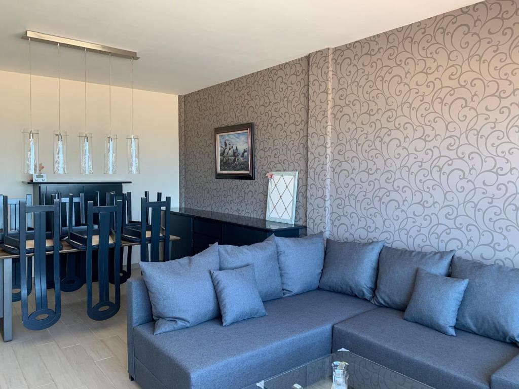 布兰肯贝赫Appartement met zeezicht的客厅配有蓝色的沙发和桌子