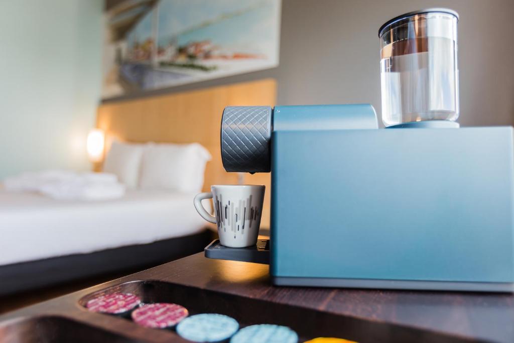 里斯本里斯本纳索艾许公园宜必思酒店的客房设有一张床、一张桌子和咖啡壶