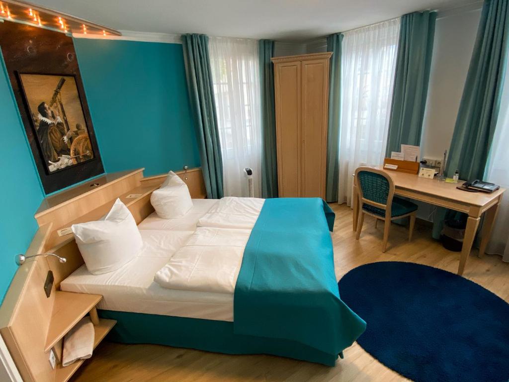 蒂宾根Hotel Am Schloss *** Superior的酒店客房配有一张床、一张书桌