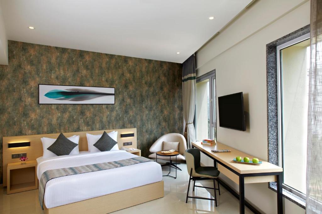 德瓦纳哈利-班加罗尔Click Hotel Bangalore - International Airport的配有一张床和一张书桌的酒店客房