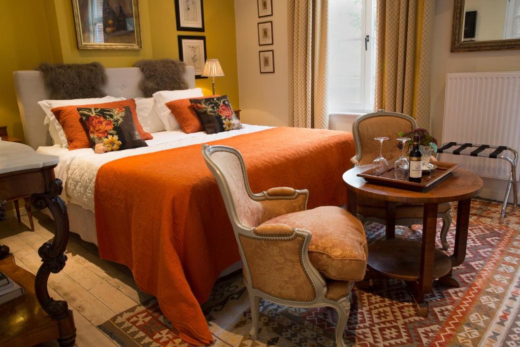 布鲁日TWO ROOMS IN BRUGES的一间卧室配有一张带橙色毯子和桌子的床