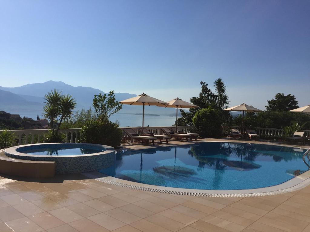赫尔采格诺维Monte Aria panorama suites的一个带桌子和遮阳伞的游泳池