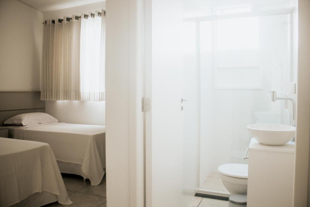 Telêmaco BorbaZen Pousada的白色的浴室设有床和卫生间。