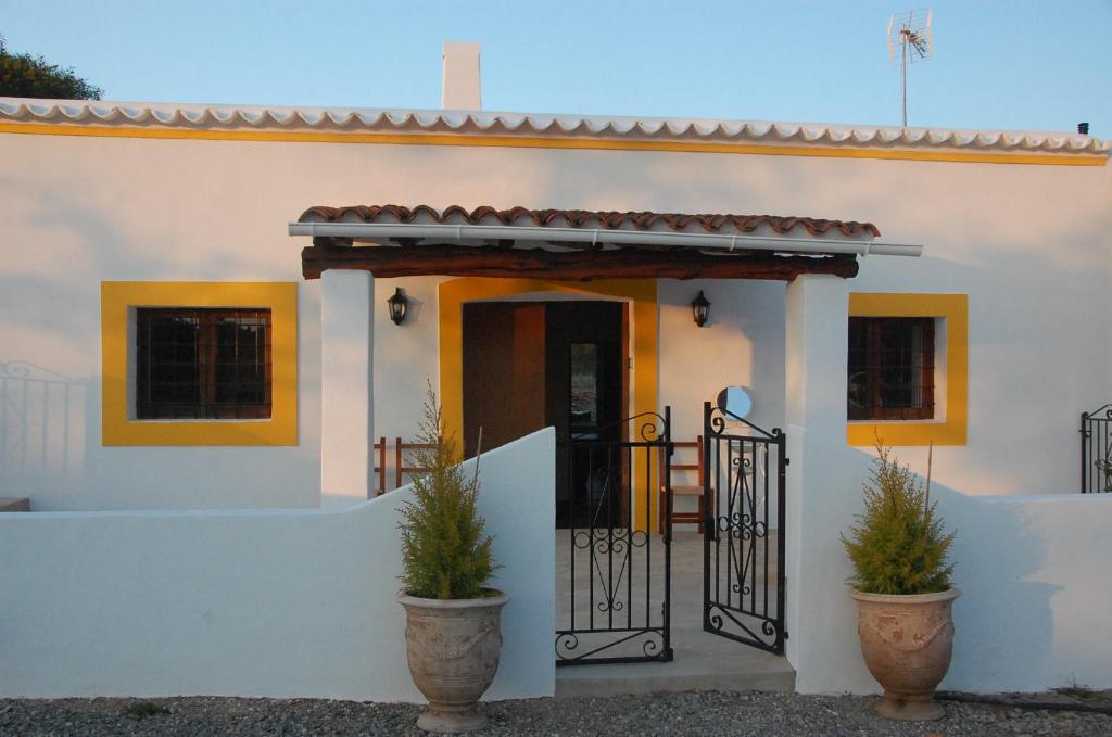 圣卡洛斯Can Jaume Guillem的白色的房子,有门和盆栽植物