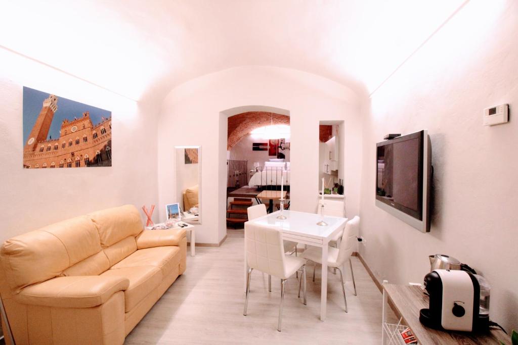 锡耶纳Suite al Duomo的客厅配有沙发和桌子