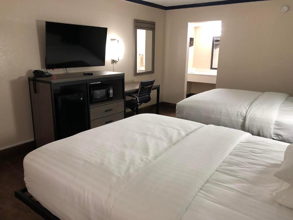 霍顿旅行者沃顿套房汽车旅馆的酒店客房设有两张床和一台平面电视。