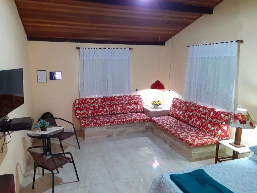 佩尼多Casa Chalé em Penedo的客厅配有红色沙发和电视