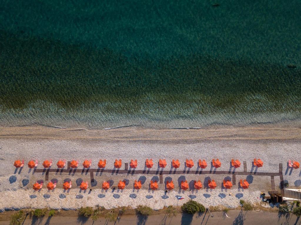 波罗斯Akrogiali Studios的海滩上的一组橙色遮阳伞