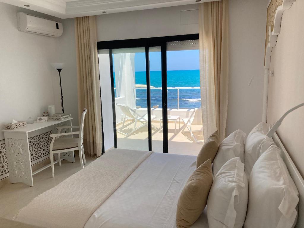 拉马萨Dar Corniche La Marsa (Adults Only)的一间卧室配有一张床,享有海景