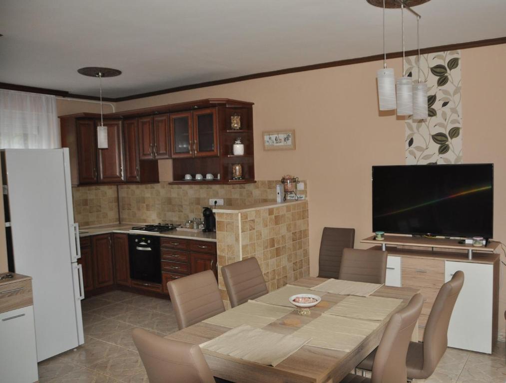 杰尔Győrszem Apartman的厨房以及带桌子和电视的用餐室。