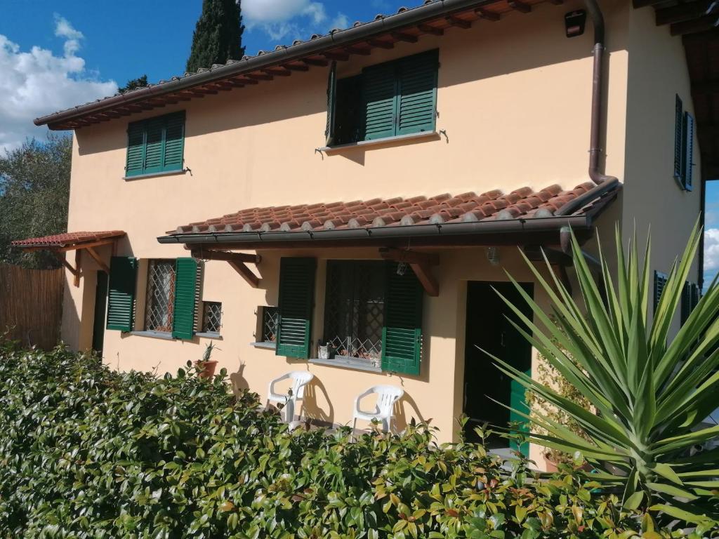 蒙泰卢波菲奥伦蒂诺La Casa delle Rondini的一座带绿色百叶窗和树 ⁇ 的房子