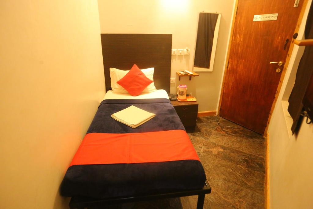 黎明之村Le Apex Home Stay的小卧室配有一张带橙色和黑色毯子的床
