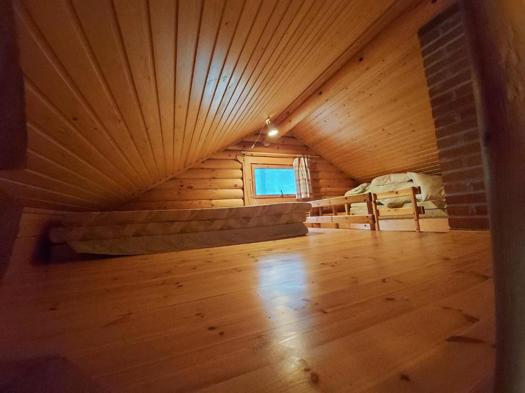 海门林纳Rantamökki Onni的阁楼间铺有木地板,设有窗户。