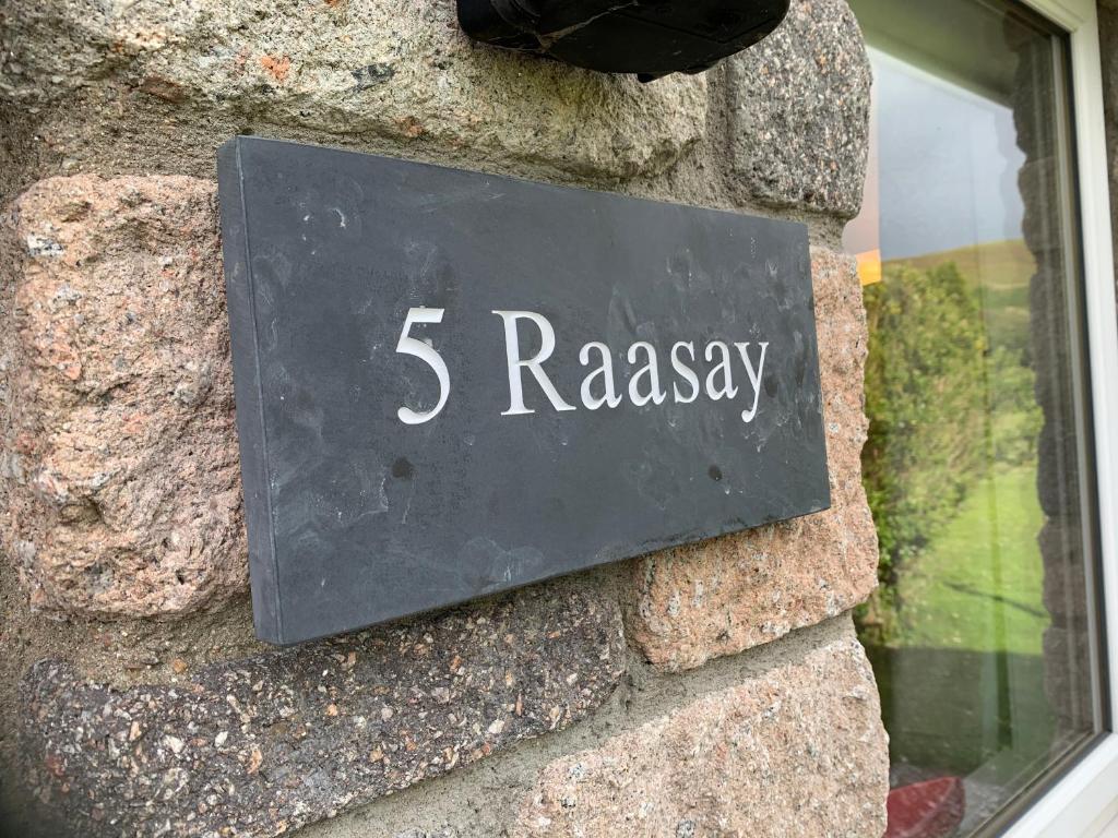 蒂恩格Raasay@Knock View Apartments, Sleat, Isle of Skye的石墙上的一个标语,带有“疯狂”的字眼