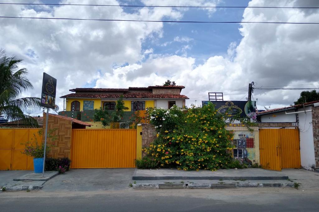 费拉迪圣安娜Apart Fraga Maia的一座带黄色围栏和灌木的房子