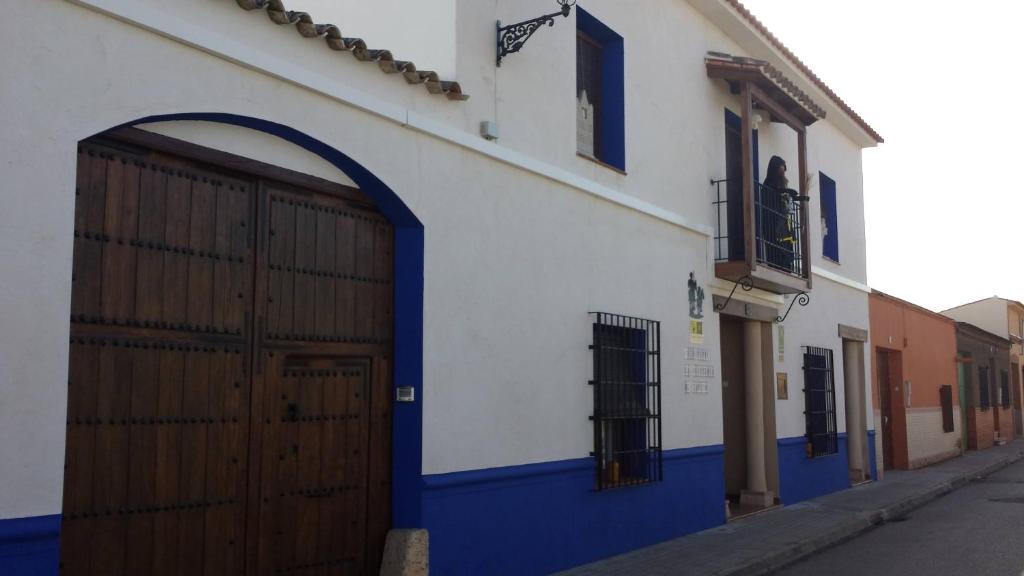 Argamasilla de AlbaHostal el lugar de la Mancha的蓝色和白色的建筑,设有大门